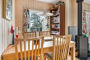 a dining room with a wooden table and chairs at Cozy Cottage At Tuse Næs In Holbæk in Holbæk +25 photos