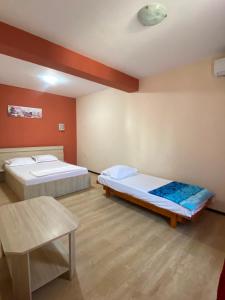 a room with two beds and a table in it at Casa Didina in Năvodari