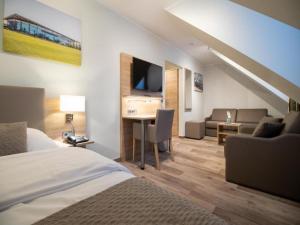 a hotel room with a bed and a desk and a couch at Wolfsburg Fallersleben Hotel by Belvilla in Wolfsburg