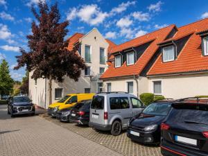 a row of cars parked in a parking lot next to houses at Wolfsburg Fallersleben Hotel by Belvilla in Wolfsburg