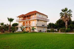 a large house with a large lawn in front of it at Pachynammos Studios & Apartments in Kypseli