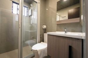 a bathroom with a toilet and a sink and a shower at Highland Nest in Baguio