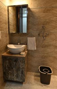 a bathroom with a sink and a mirror at Hadendra Residences in Jaipur +97 photos