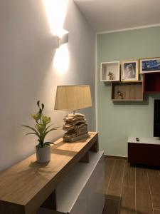 a room with a table with a lamp and a plant at Casa vacanza Gea - Superior Apartment in Bergamo city with private parking car in Bergamo