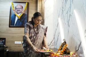 a woman holding a plate of food on a table at Hotel Sopan Heights in New Delhi