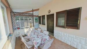 a dining room with a table and chairs on a balcony at Apartment Viola - Pavićini, Duga Uvala in Krnica