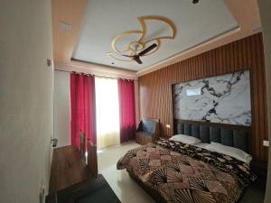 a bedroom with a bed and a ceiling fan at Hotel Ajay Palace in Pīpalkoti +4 photos