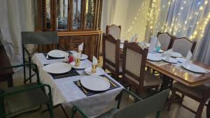 a dining room table with white plates on it at Chobe Kulotu Guest House in Kasane