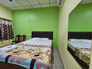 two beds in a room with green walls at Harmony - Havelock Island in Havelock Island