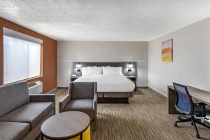 a hotel room with a bed and a couch at Comfort Inn Paramus - Hackensack in Paramus