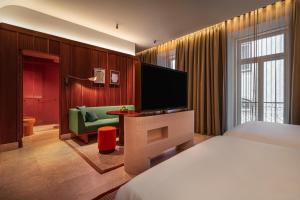 a hotel room with a bed and a flat screen tv at Andaz Lisbon, By Hyatt in Lisbon