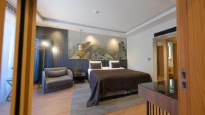 a hotel room with a bed and a chair at Amorium Hotel in Kastamonu