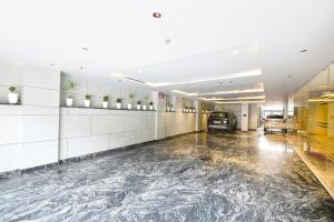 a large hall with a marble floor in a car dealership at Hotel Elvilla Model Town in New Delhi