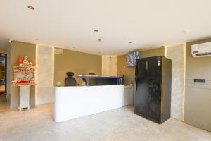 a kitchen with a white counter and a refrigerator at Hotel Elvilla Model Town in New Delhi