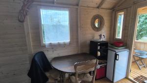 a small room with a table and a window at La Roulotte Cacahuète in Pont-d'Ouilly