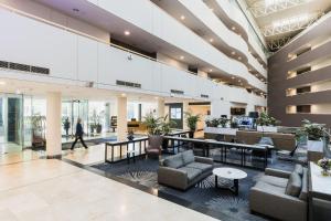 a lobby with couches and tables in a building at Crowne Plaza Canberra by IHG in Canberra
