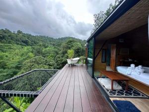 a room with a deck with a bath tub and a view at Camp Mai Mee Chue in Pong Yaeng