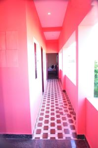 a hallway with pink walls and a checkered floor at Dharani Residency in Pondicherry +2 photos