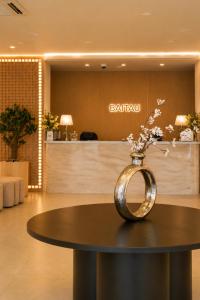 a vase with flowers sitting on a table in a lobby at Baitau Hotel Aktobe in Aktobe