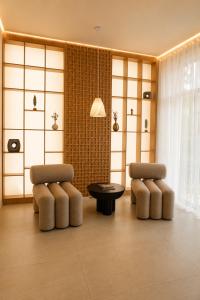 a living room with two chairs and a table at Baitau Hotel Aktobe in Aktobe +39 photos
