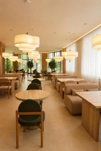 a lobby with tables and couches and chairs at Baitau Hotel Aktobe in Aktobe