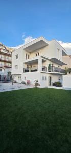 a large white house with a green lawn at Apartment Zore in Promajna