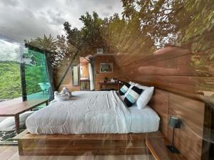 a bedroom with a large bed and a wooden wall at Camp Mai Mee Chue in Pong Yaeng