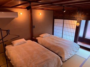 a bedroom with two beds in a room at ふくさぶろ in Ushikubi