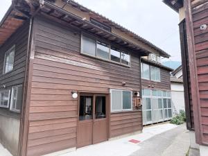 a house with wooden siding and a garage at ふくさぶろ in Ushikubi