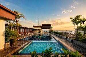 a swimming pool with the ocean in the background at Baywalk Residence Pattaya in Pattaya