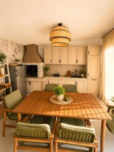 a kitchen with a wooden table and green chairs at Villa Vida, Medulin - Bazen i jacuzzi in Medulin
