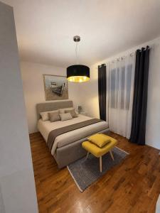 a bedroom with a bed and a yellow stool at Villa Vida, Medulin - Bazen i jacuzzi in Medulin +33 photos