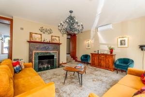 a living room with yellow furniture and a fireplace at Vila Ieva in Palanga