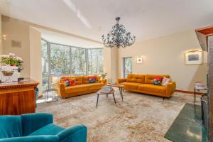 a living room with two couches and a chandelier at Vila Ieva in Palanga