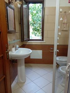 a bathroom with a sink and a toilet and a window at B&B Zia Delia in Villaperuccio +42 photos