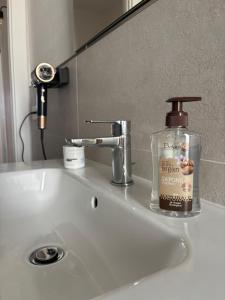 a bottle of soap sitting on a bathroom sink at Serendipity in Elmas +35 photos