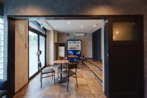 a hallway with a table and chairs in a room at YAMATO - Doyanen Hotels in Osaka