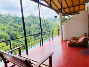 a balcony with a bench and a view of the forest at Rawana Mountain View Homestay in Ella