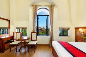 a bedroom with a bed and a desk and a table at Maro Boutique Villa in Da Lat +81 photos