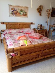 a wooden bed with pillows on it in a room at B&B Zia Delia in Villaperuccio