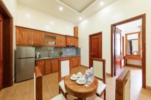 a kitchen with a wooden table and a dining room at Maro Boutique Villa in Da Lat