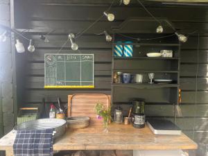a wooden table in a kitchen with a chalkboard at Glamping - a living room overlooking the ocean in Hammarland