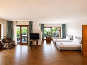a living room with a white couch and a television at Hotel Relais Königsberg in Aachen