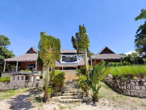 a house with palm trees in front of it at Antsanitia - Domaine du Mandravasarotra - DDM in Antsianitia