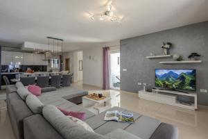 a living room with a couch and a tv at Villa Luka with Private Pool & Sea View in Labin