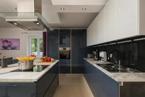a large kitchen with black and white appliances at Villa Luka with Private Pool & Sea View in Labin