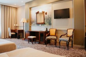 a hotel room with a desk and a bed at Grand Hotel Victory in Aktau