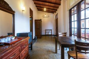 a room with a table and a dining room with windows at Nova By Horizon Collection in Unawatuna