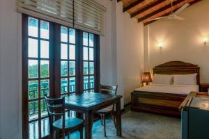 a bedroom with a bed and a table and chairs at Nova By Horizon Collection in Unawatuna +73 photos
