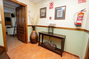 a hallway with a vase and a table with a lamp at posada trastamara in Piedralaves